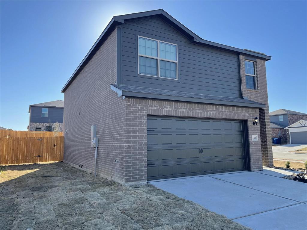 Two-story exterior featuring a brick and horizontal siding façade, a dual-car garage, and a concrete driveway Two-story exterior featuring a brick and horizontal siding façade, a dual-car garage, and a concrete driveway