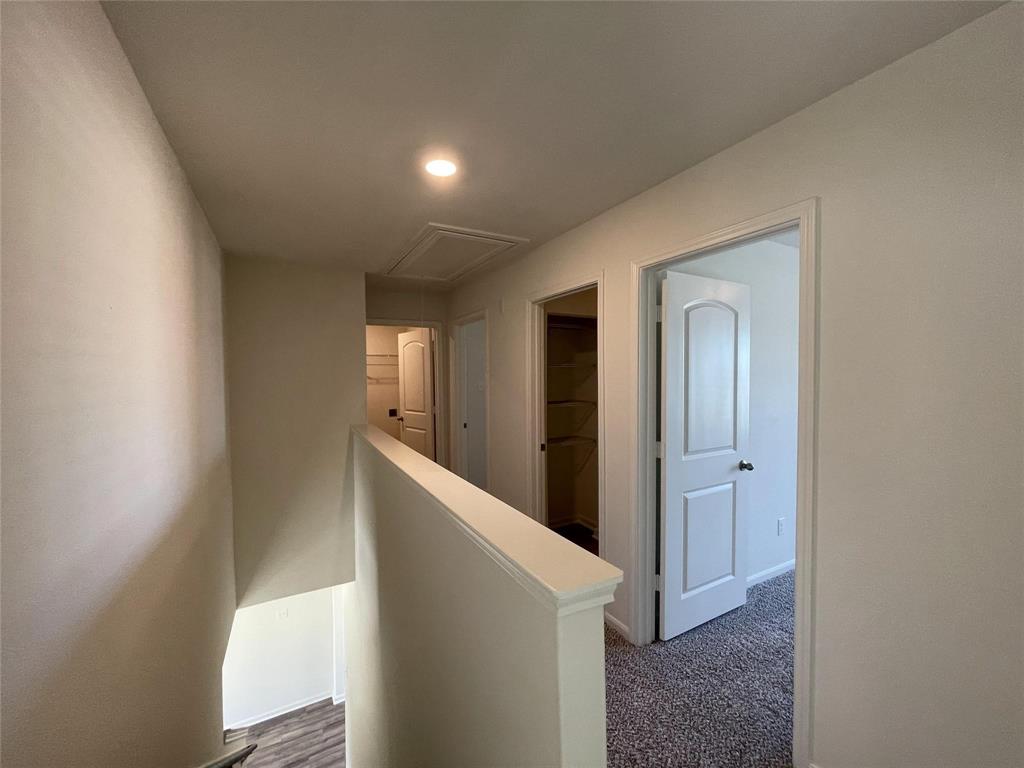 Neutral-toned interior featuring recessed lighting, carpeted flooring, raised-panel interior doors, and built-in closet shelving