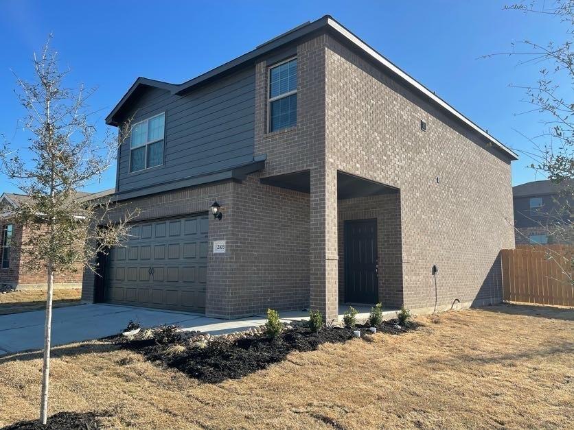 Two-story exterior featuring a brick facade with horizontal siding accents, a concrete driveway, a covered entry, and a multi-panel garage door Two-story exterior featuring a brick facade with horizontal siding accents, a concrete driveway, a covered entry, and a multi-panel garage door