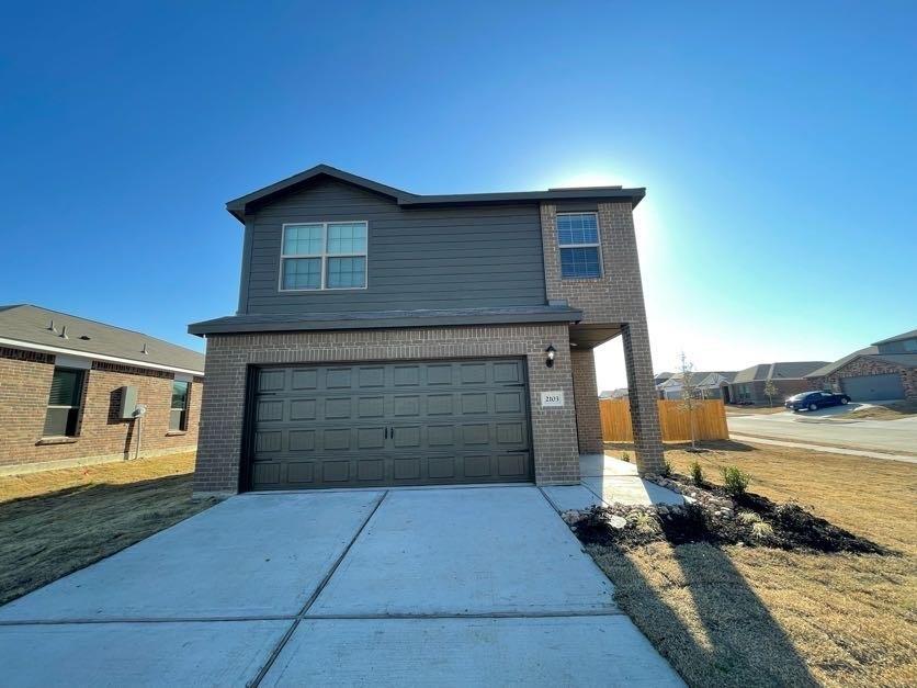 Two-story exterior featuring a brick and horizontal siding facade, an attached two-car garage, and a concrete driveway Two-story exterior featuring a brick and horizontal siding facade, an attached two-car garage, and a concrete driveway