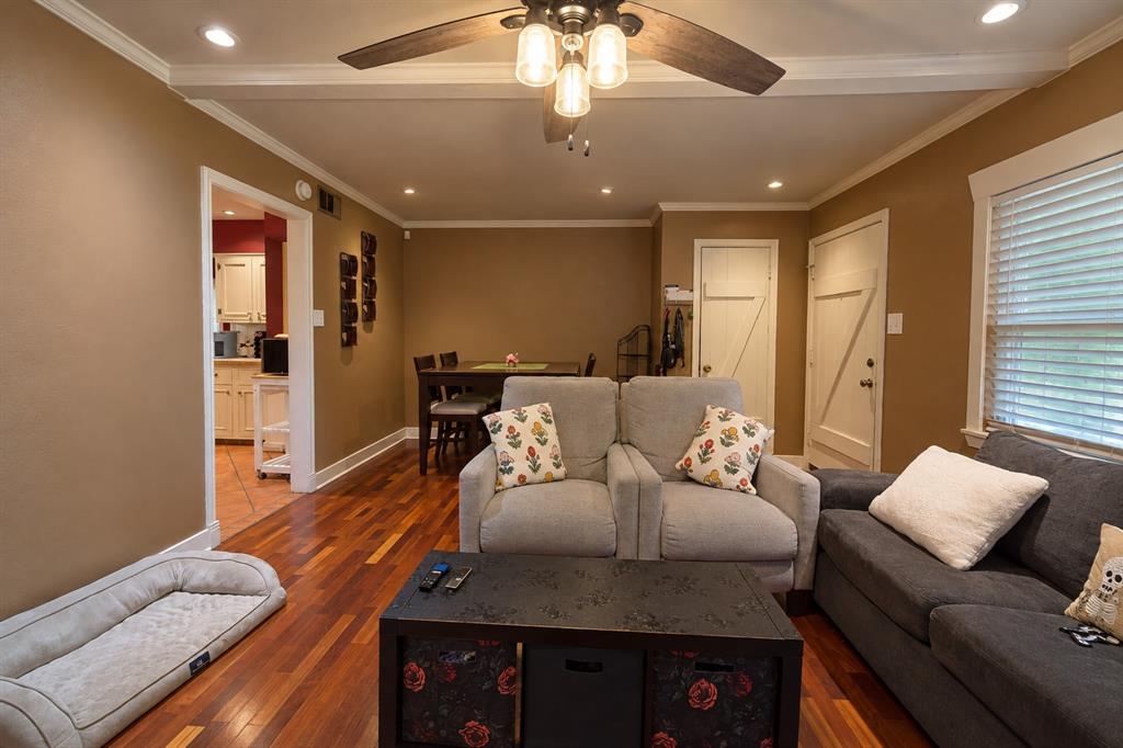 Living area featuring polished wood-finish flooring, recessed lighting, crown molding, and a central ceiling fan with integrated lighting Living area featuring polished wood-finish flooring, recessed lighting, crown molding, and a central ceiling fan with integrated lighting
