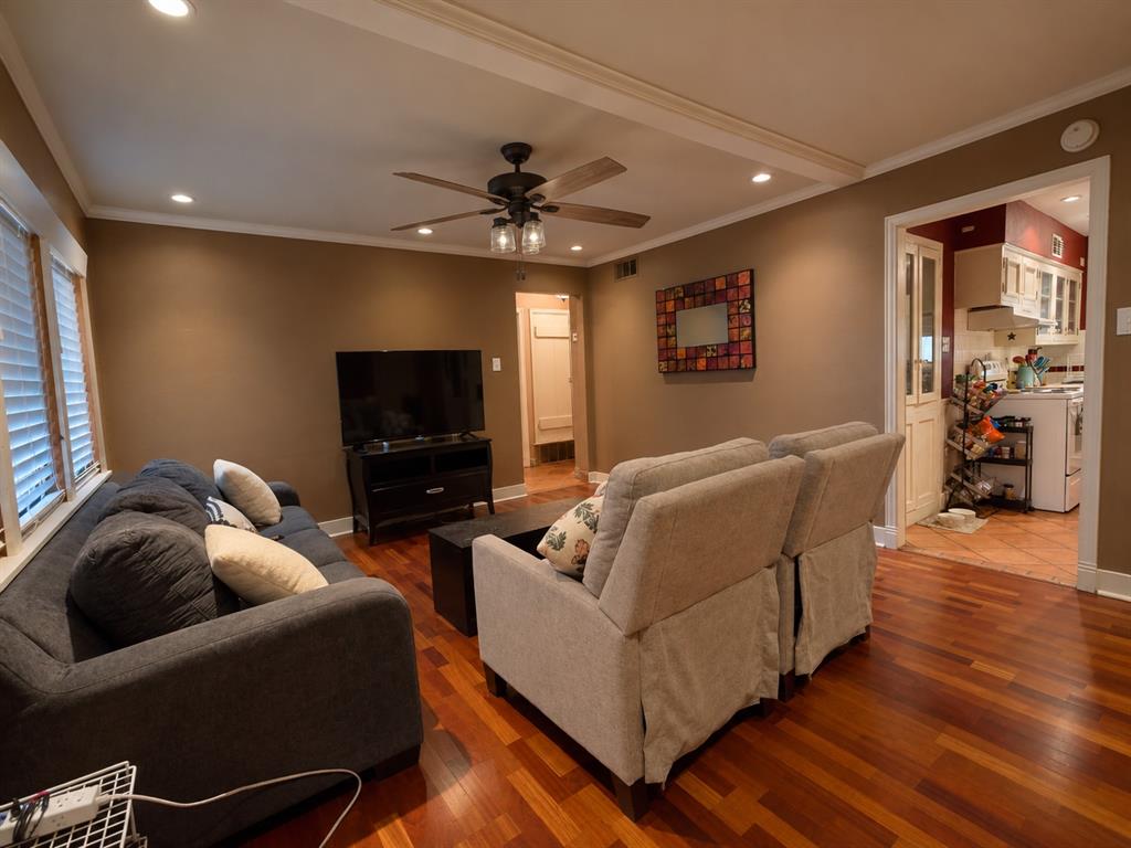 Wood-finish flooring, recessed lighting, and a central ceiling fan with integrated lighting Wood-finish flooring, recessed lighting, and a central ceiling fan with integrated lighting