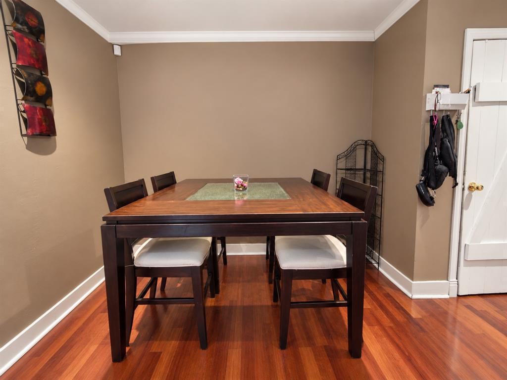 Wood-finish flooring, crown molding, and a solid-core door with brass hardware Wood-finish flooring, crown molding, and a solid-core door with brass hardware