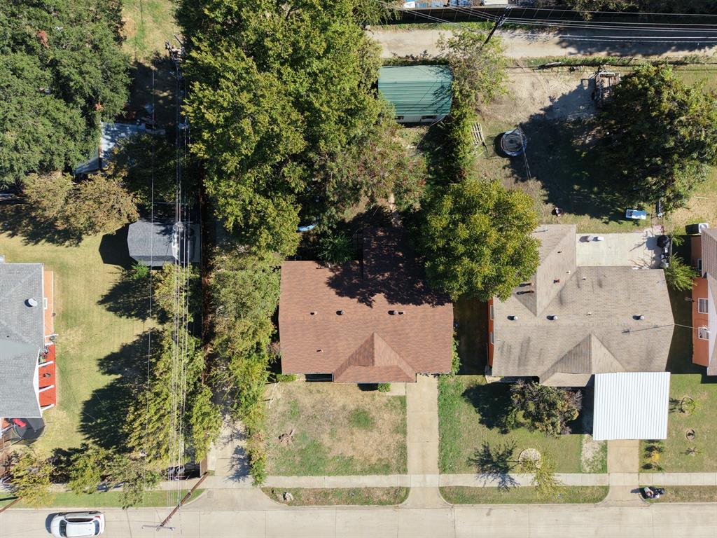 Aerial perspective of the property featuring a shingled roof, concrete driveway, and mature landscaping Aerial perspective of the property featuring a shingled roof, concrete driveway, and mature landscaping