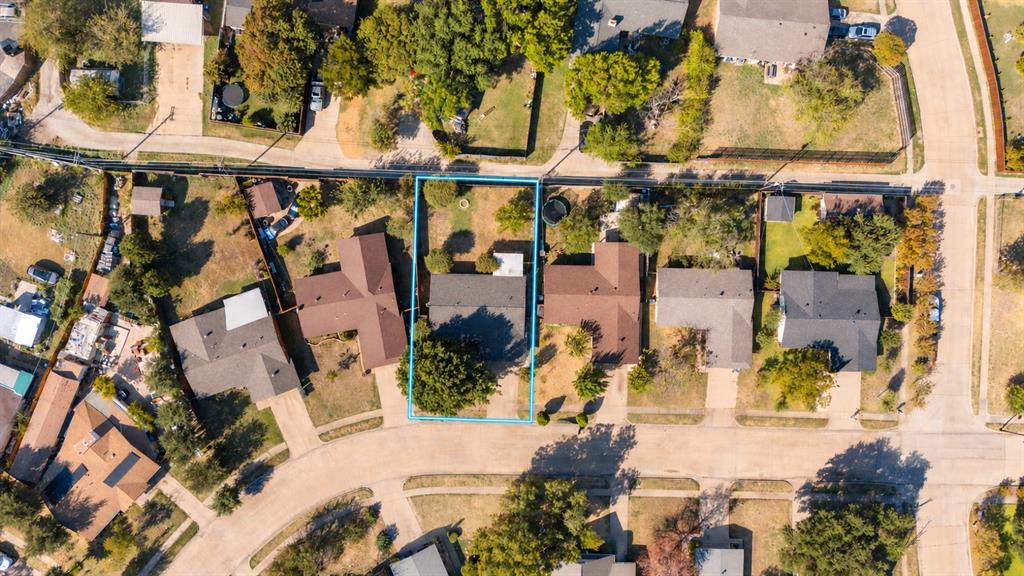Aerial perspective of a residential property featuring an expansive backyard, mature landscaping, and a rectangular lot configuration