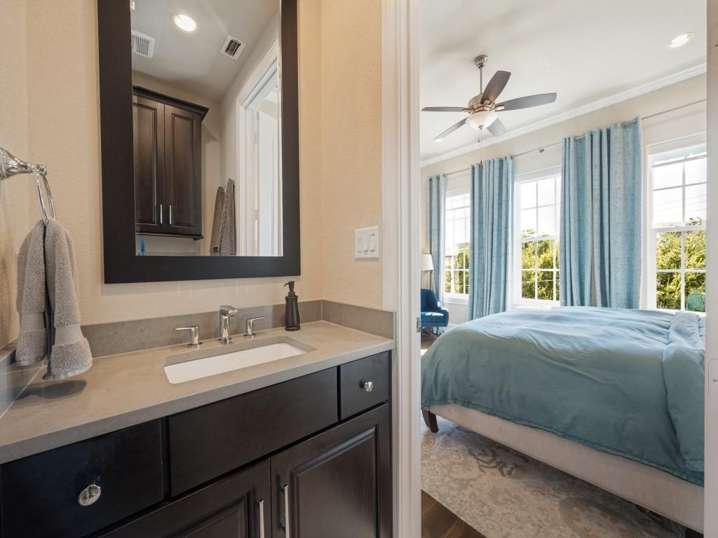 The Primary Bath Features a Standing Hight Counter, Granite Counters, Framed Mirror and Walk-in Shower