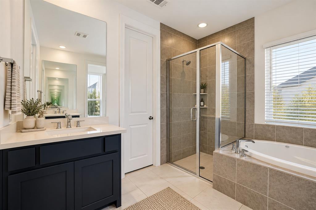 Spacious primary bathroom featuring separate vanities for added comfort and convenience.