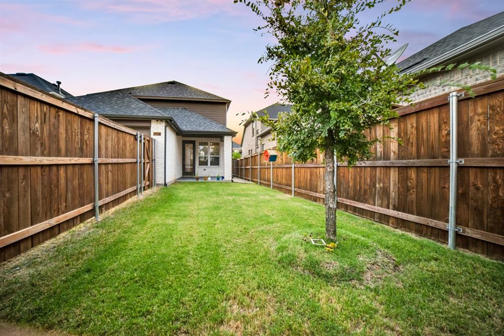Generously sized backyard featuring a covered patio, perfect for outdoor entertaining, play, or relaxation.