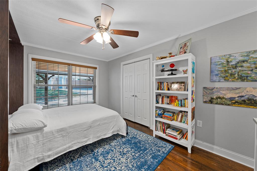 Wood-finish flooring, multi-panel closet doors, and ceiling fan with integrated light fixture