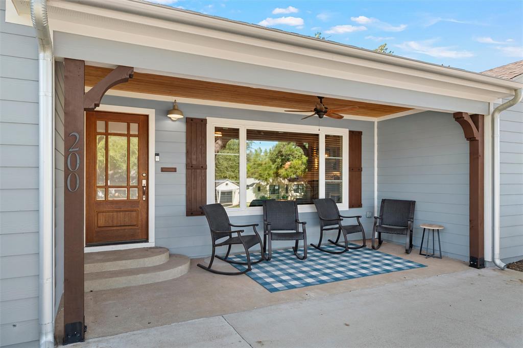 Covered front porch featuring wood-finish ceiling detailing, decorative corbels, horizontal siding, and a multi-pane wood entry door