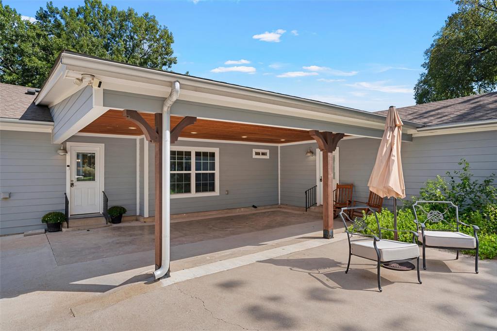Covered patio featuring a wood-plank ceiling, structural timber support posts, recessed lighting, and concrete flooring