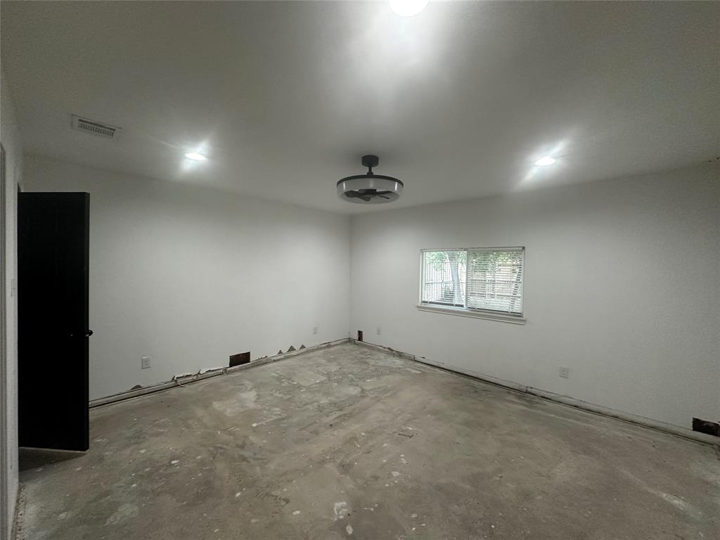 Interior space featuring recessed lighting, a ceiling fan with integrated light fixture, a horizontal sliding window, and a contrasting black interior door Interior space featuring recessed lighting, a ceiling fan with integrated light fixture, a horizontal sliding window, and a contrasting black interior door
