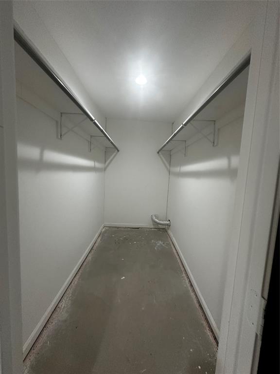 Reach-in closet featuring dual-sided metal shelving and hanging rods