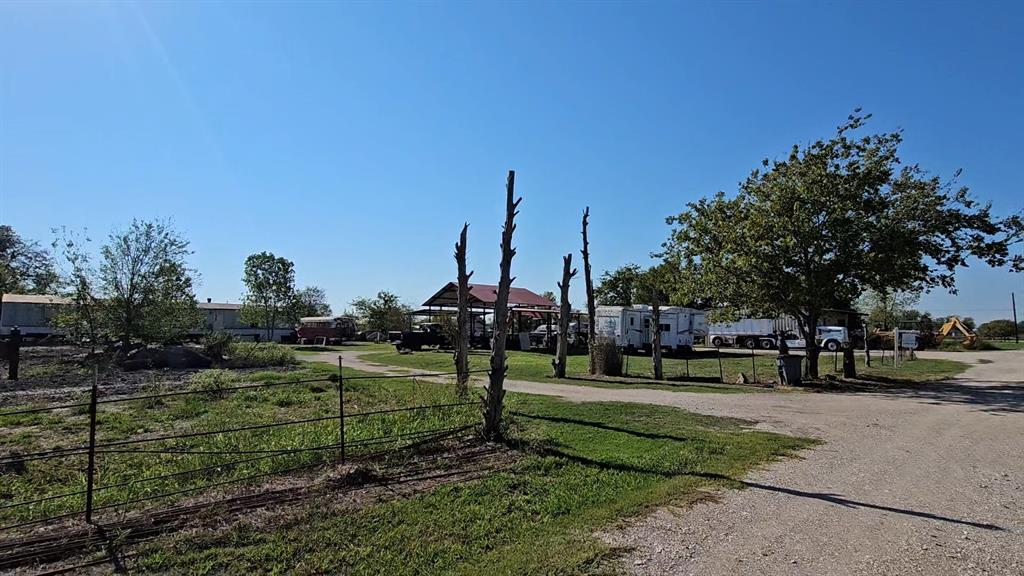Expansive lot featuring a metal-roofed covered structure and mature trees Expansive lot featuring a metal-roofed covered structure and mature trees