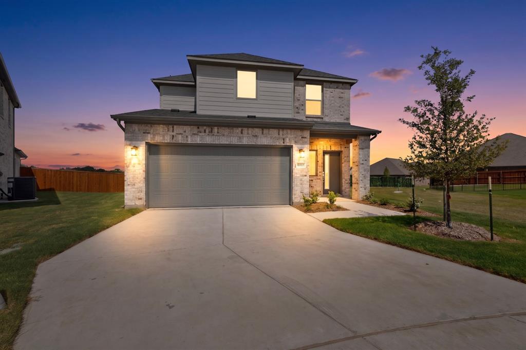 Two-story residence featuring a combination of brick and horizontal siding exterior, a two-car garage, and a concrete driveway