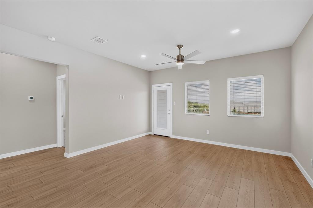 Living area featuring wood-finish flooring, recessed lighting, a ceiling fan with integrated light, two windows with horizontal blinds, and a glass-panel exterior door Living area featuring wood-finish flooring, recessed lighting, a ceiling fan with integrated light, two windows with horizontal blinds, and a glass-panel exterior door