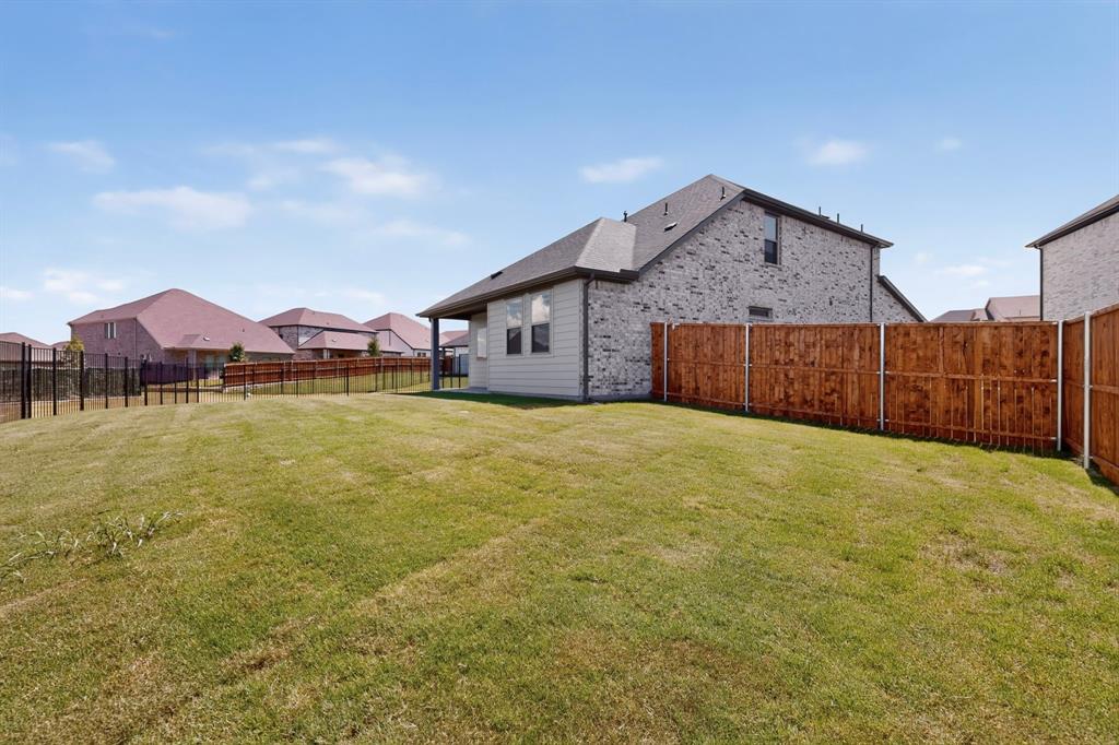 Expansive backyard featuring a sodded lawn and privacy wood fencing