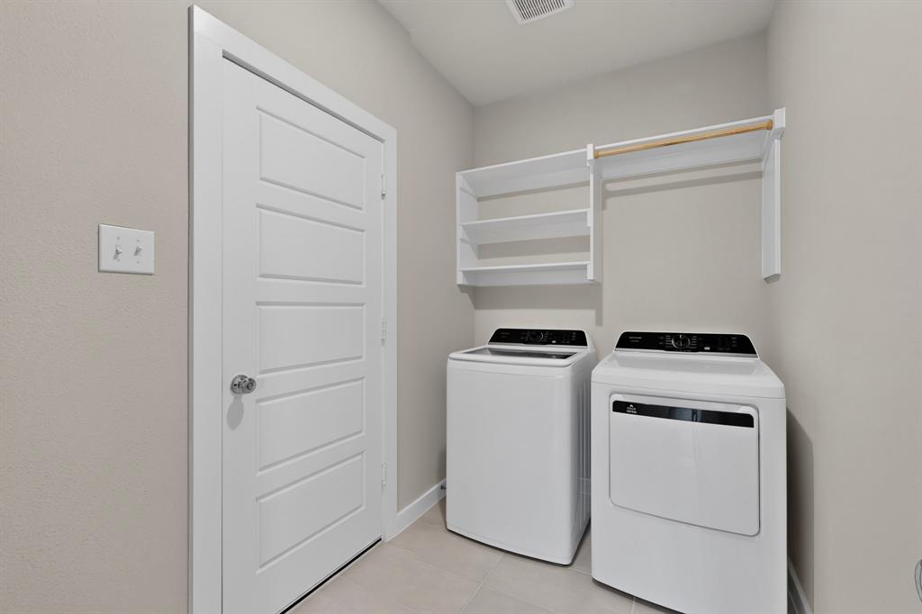 Neutral-toned space featuring ceramic tile flooring, a solid-core four-panel door, and white built-in shelving with an integrated clothes rod