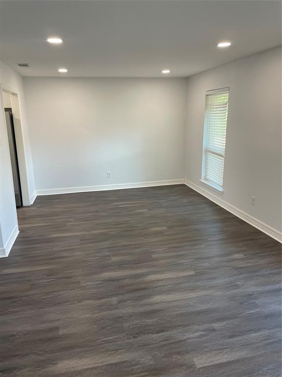 Interior space featuring wood-finish flooring, recessed lighting, and a single window with fitted blinds