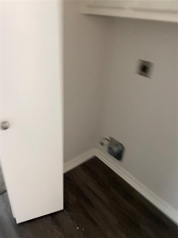 Utility alcove featuring wood-finish flooring, built-in upper cabinetry, and laundry hookups