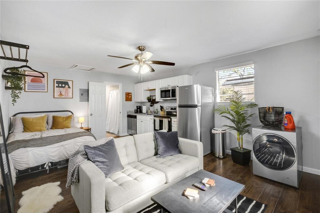Kitchenette featuring white cabinetry, stainless steel appliances, wood-finish flooring, and a ceiling fan with integrated lighting