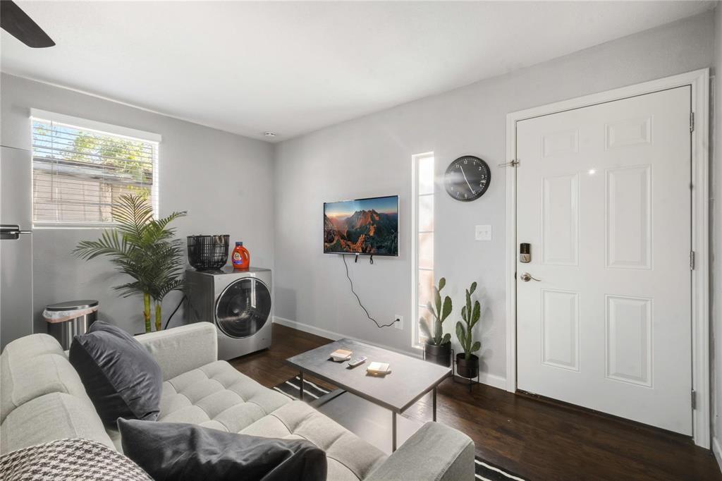 Interior space featuring dark wood-finish flooring, neutral wall tones, a vertical window, and a multi-panel exterior entry door