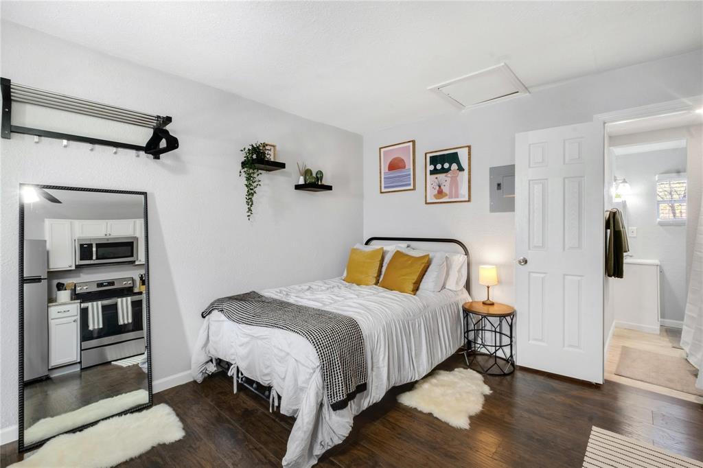 Wood-finish flooring, two wall-mounted floating shelves, and a six-panel interior door