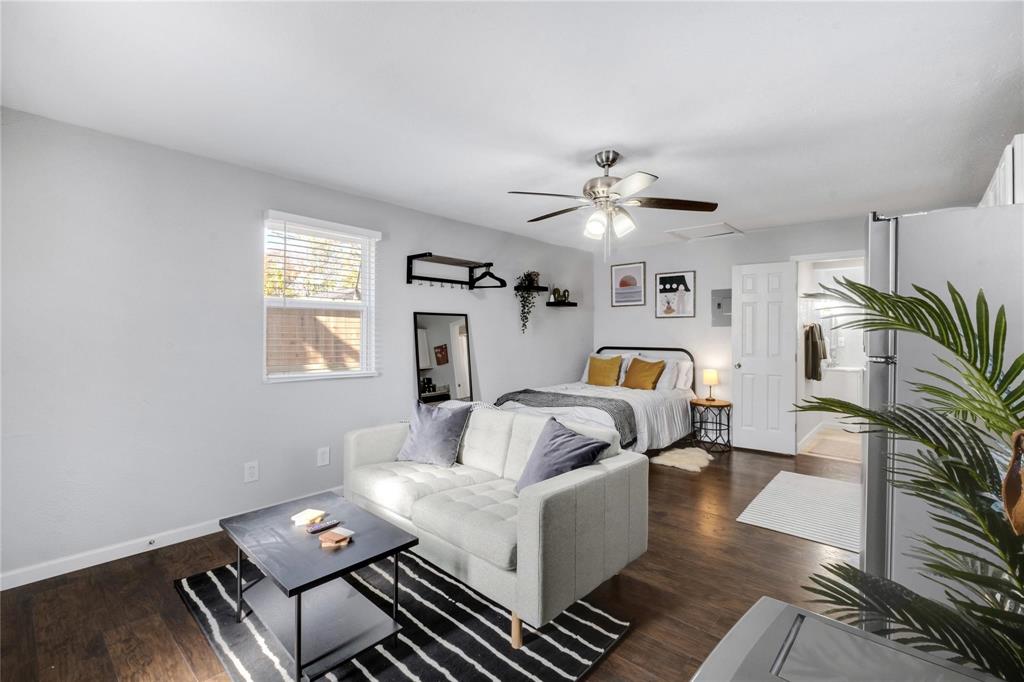 Wood-finish flooring, multi-blade ceiling fan with integrated lighting, and white six-panel interior door