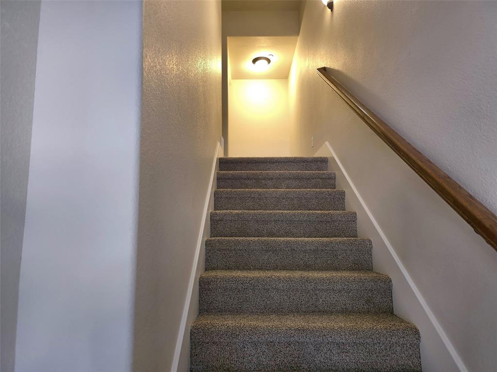 Staircase featuring wall-to-wall carpeting, wood-finish handrail, and integrated ceiling lighting Staircase featuring wall-to-wall carpeting, wood-finish handrail, and integrated ceiling lighting