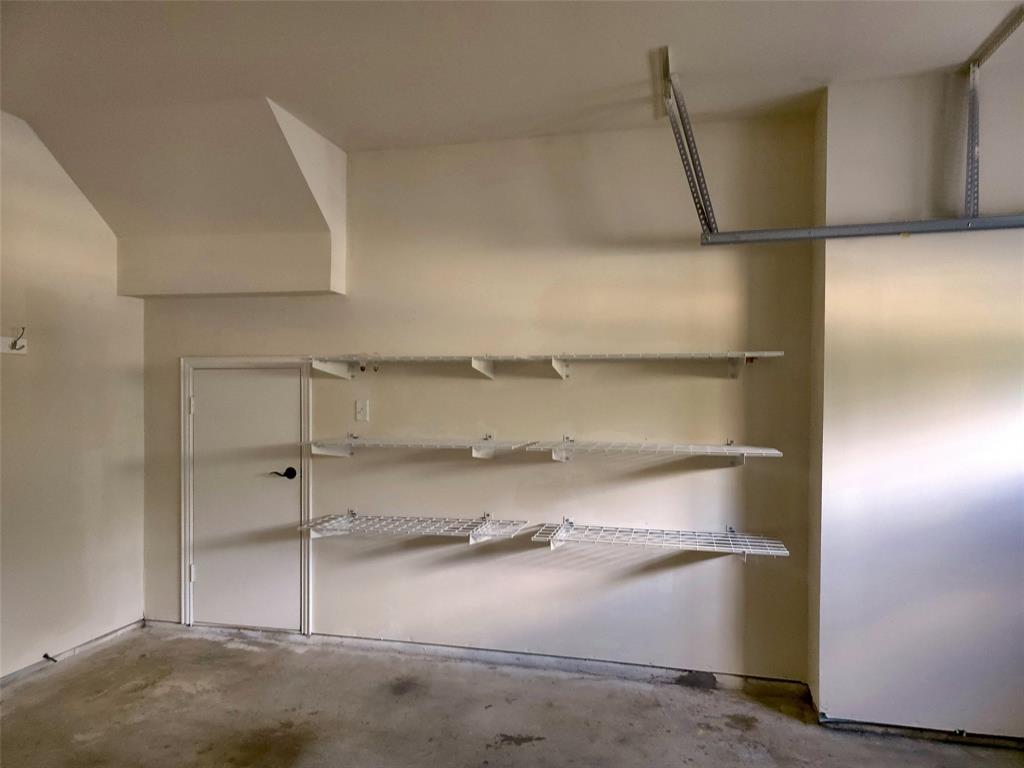 Interior space featuring three levels of wall-mounted wire shelving and a solid-core utility door with matte black hardware