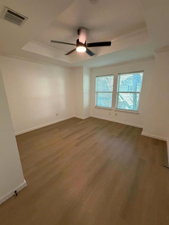 2nd Bedroom with tray ceiling, wood-finish flooring, and a modern ceiling fan with integrated lighting