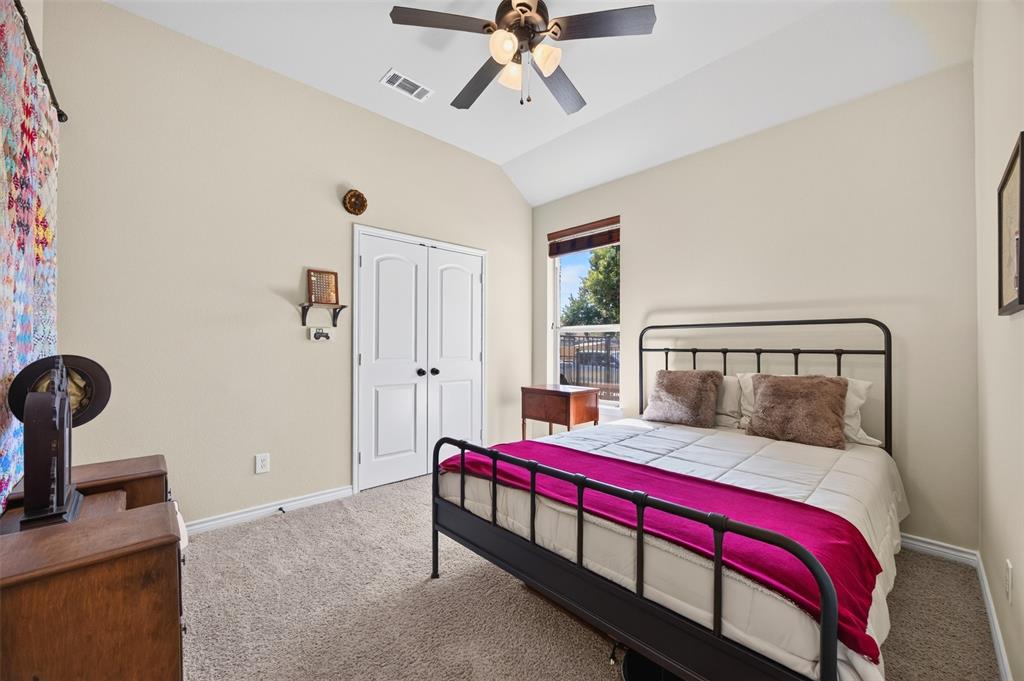Vaulted ceilings, neutral carpeting, double-door closet, and overhead ceiling fan with light fixture