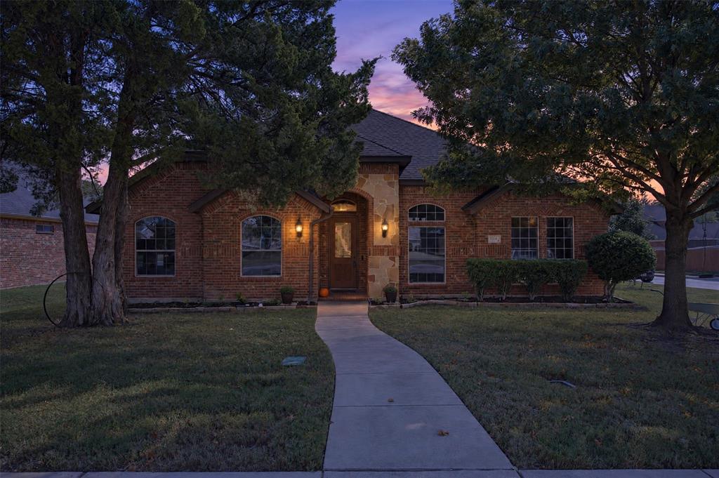 Brick and stone facade featuring an arched entryway, stone detailing, arched windows, and a concrete walkway Brick and stone facade featuring an arched entryway, stone detailing, arched windows, and a concrete walkway