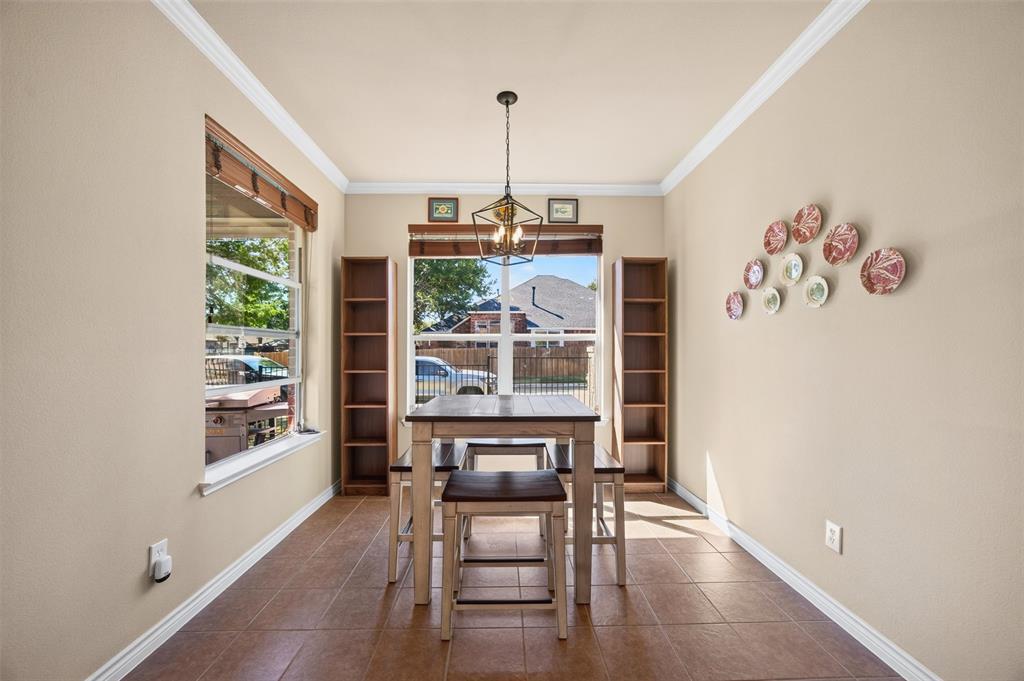 Tile flooring, crown molding, built-in wooden shelving, dual windows, and an industrial-style geometric pendant light fixture