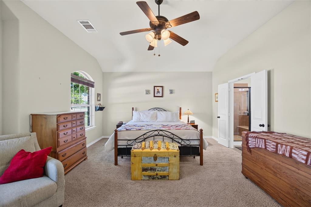 Vaulted ceilings, carpeting, arched window, and integrated multi-blade ceiling fan with light fixture