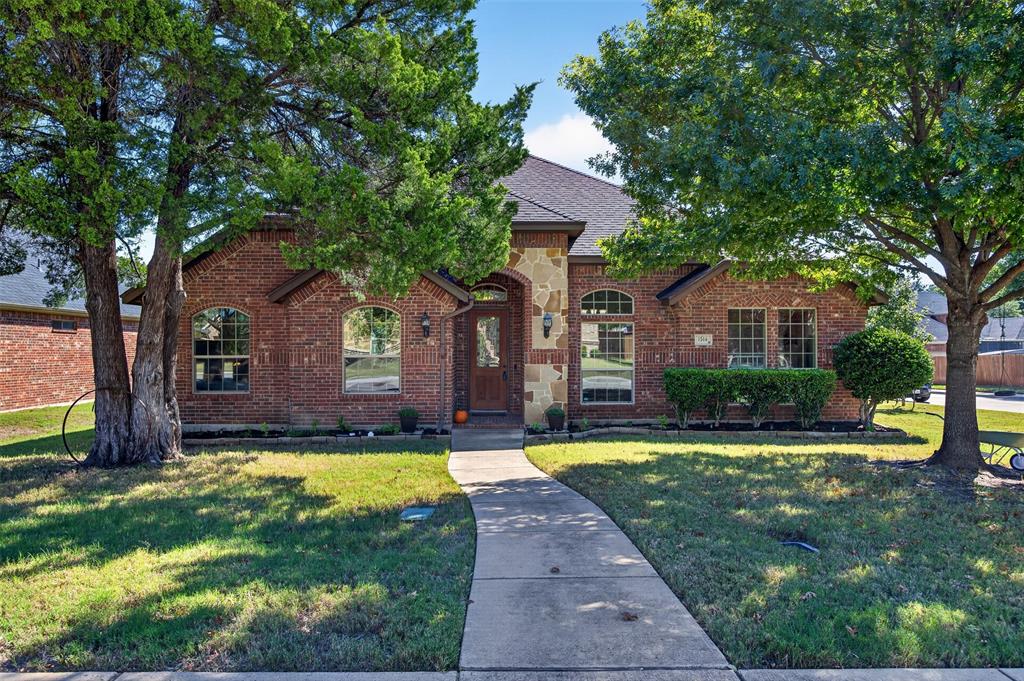 Brick exterior featuring stone accents, arched window detailing, and a multi-gabled roofline