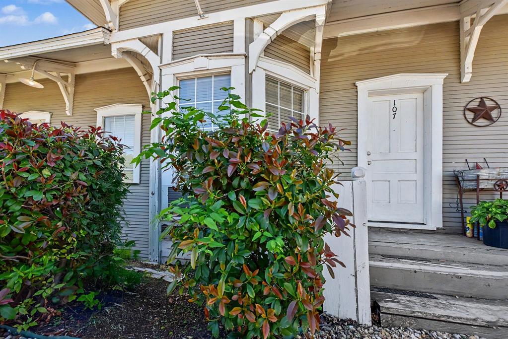 Exterior entrance featuring horizontal lap siding, decorative corbel brackets, multi-pane windows, and a raised entry landing with stairs