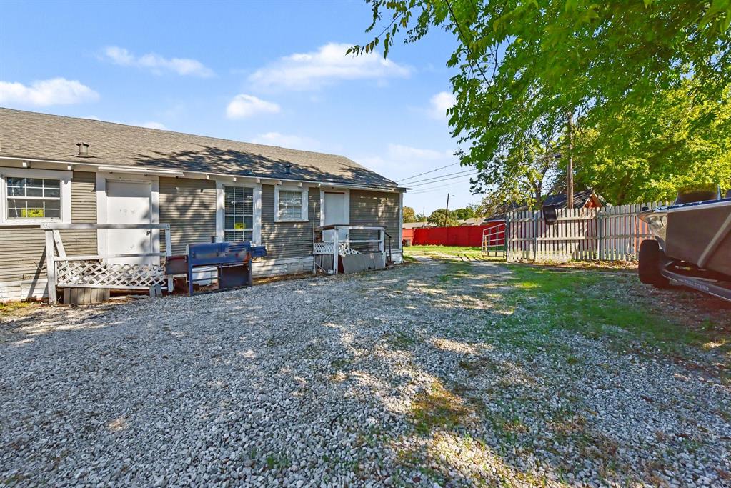 Exterior siding, gravel driveway, and perimeter wood fencing