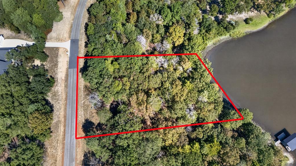 Wooded residential lot featuring extensive shoreline and direct paved road access