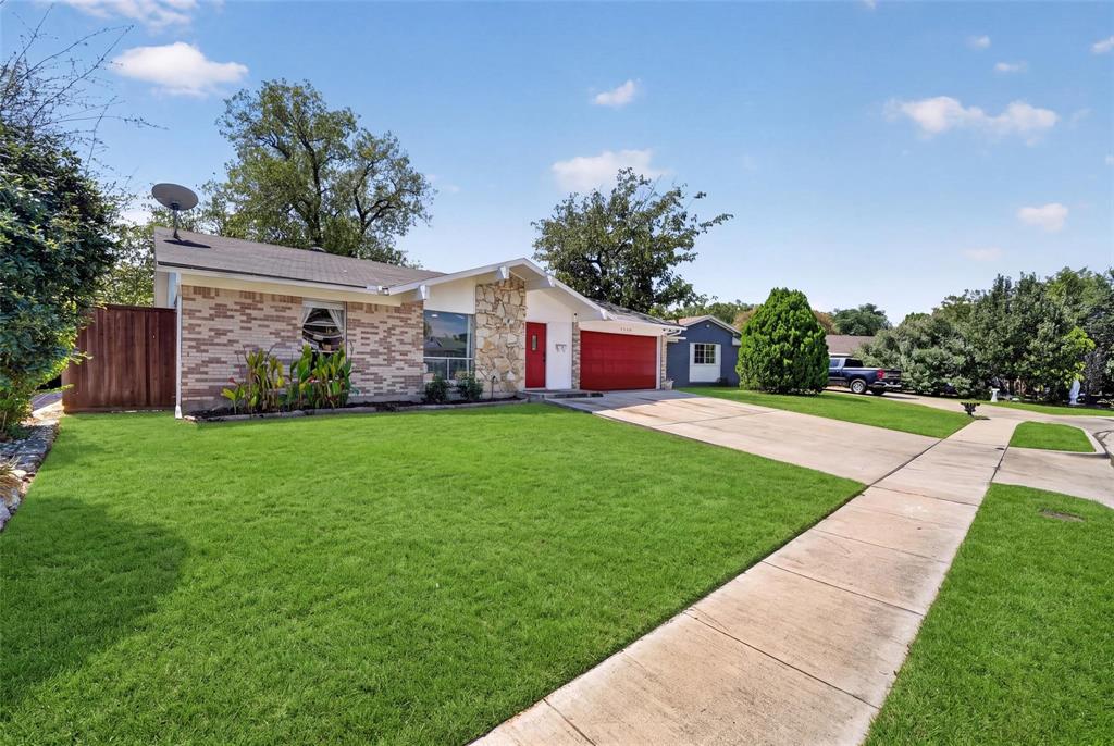 Single-story exterior featuring multi-toned brick facade, natural stone accent wall, concrete driveway, and attached garage Single-story exterior featuring multi-toned brick facade, natural stone accent wall, concrete driveway, and attached garage