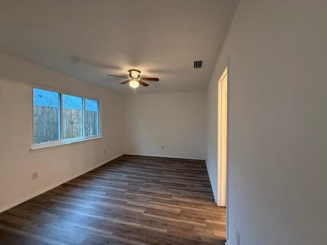 Interior room featuring wood-finish flooring, a multi-pane window, and a ceiling-mounted fan with light fixture Interior room featuring wood-finish flooring, a multi-pane window, and a ceiling-mounted fan with light fixture