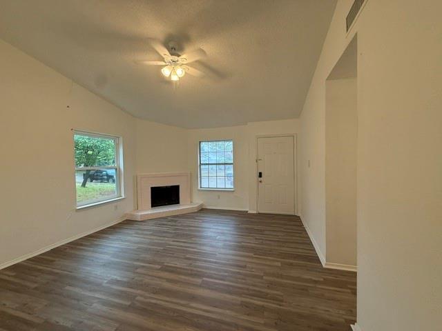 Vaulted ceilings, wood-finish flooring, corner fireplace with raised hearth, and multiple windows providing natural light Vaulted ceilings, wood-finish flooring, corner fireplace with raised hearth, and multiple windows providing natural light