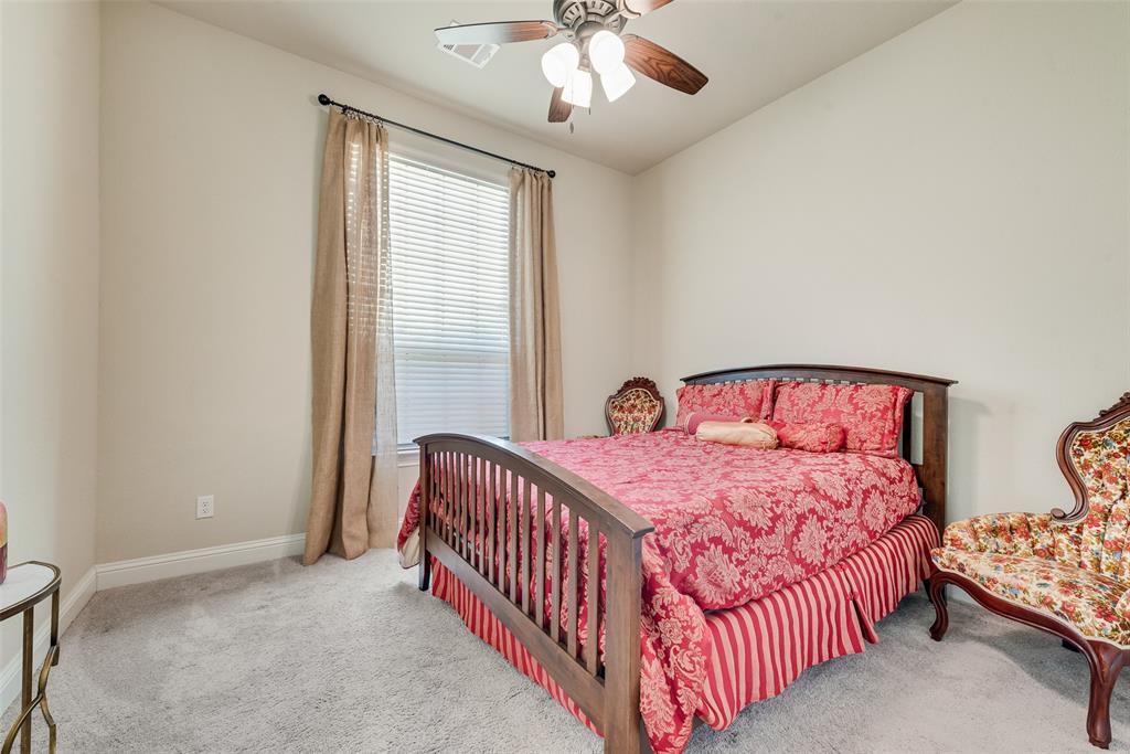Neutral wall color, carpeted flooring, window with blinds, and a ceiling-mounted light fixture with fan