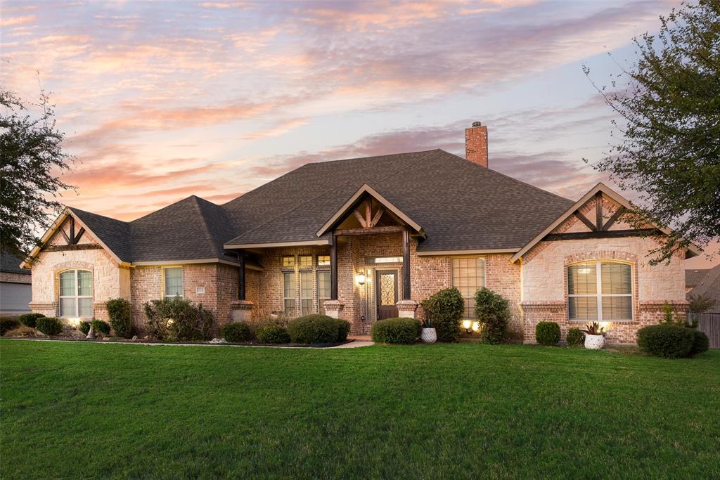 Single-story brick exterior featuring a multi-gabled roofline, decorative timber gable accents, a brick chimney, and a covered front entryway