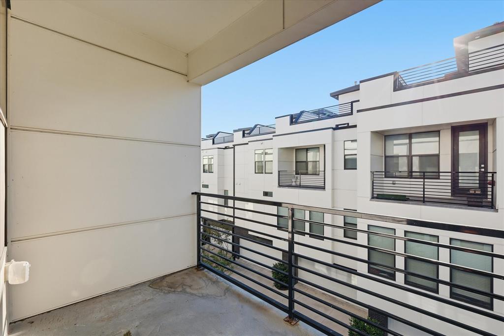 Covered balcony featuring horizontal metal railings and smooth panel exterior cladding