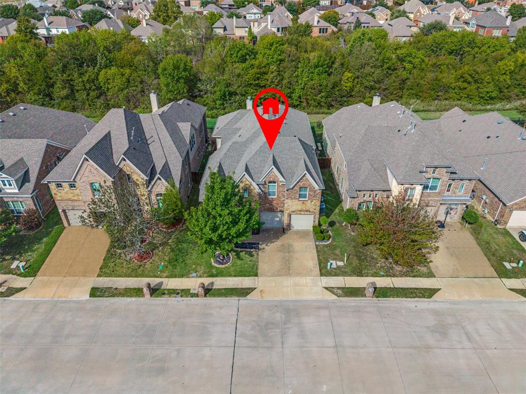 Two-story brick exterior with a multi-gabled roofline, concrete driveway, and attached garage