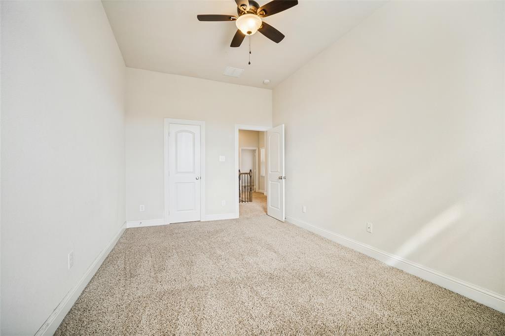 High ceilings featuring a central ceiling fan with integrated lighting and neutral carpeting