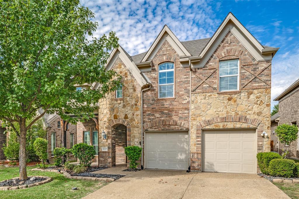 Two-story exterior featuring multi-gabled rooflines, stone and brick masonry, arched entryway, and a dual-bay garage Two-story exterior featuring multi-gabled rooflines, stone and brick masonry, arched entryway, and a dual-bay garage