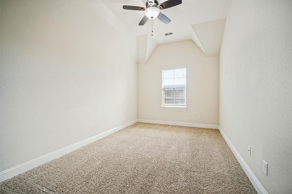 Room featuring a vaulted ceiling, neutral wall coloring, carpeted flooring, a single window with blinds, and an integrated ceiling fan