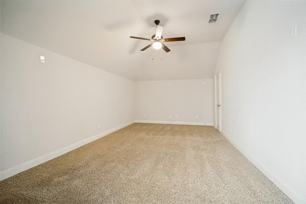 Vaulted ceilings, neutral carpeting, and a ceiling fan with integrated lighting